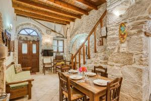 een keuken en eetkamer met een tafel en stoelen bij Medieval Villa Philoxenia in Kalamoti