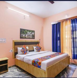 een slaapkamer met een groot bed met blauwe gordijnen bij Malti Guest House in Kullu Manali