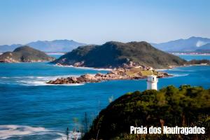 un phare sur une île rocheuse dans l'océan dans l'établissement Próximo das 42 Praias, à Florianópolis 11 autres photos