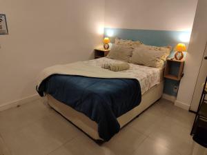 a bedroom with a large bed with two lamps at Studio no coração de Petrópolis in Petrópolis