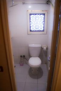 a small bathroom with a toilet and a window at Floating Hotel- Happy Nile Boat in Luxor