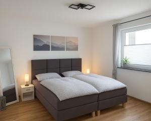 a bedroom with a large bed and a window at M&M AusZeit im Schwabenländle in Winterlingen