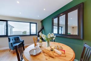 una sala da pranzo con tavolo in legno e 2 finestre di 1 Bed in Woolacombe oc-nestal a Woolacombe