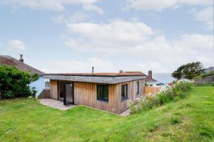 una piccola casa in legno su una collina erbosa di 1 Bed in Woolacombe oc-nestal a Woolacombe Altre 4 foto