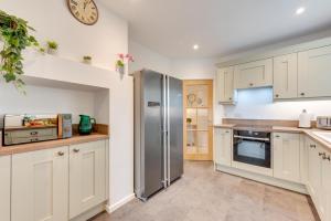 a kitchen with white cabinets and a stainless steel refrigerator at 4 Bed in Langton Matravers oc-wy548 in Langton Matravers +11 photos