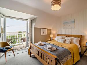 une chambre avec un grand lit et un balcon dans l'établissement 4 Bed in Dorchester oc-dc149, à Swyre