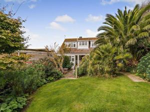 une grande maison avec un palmier dans la cour dans l'établissement 4 Bed in Dorchester oc-dc149, à Swyre