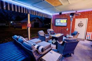 un patio con sedie in vimini, un tavolo e una televisione di Little Pigeon Millhouse a Pigeon Forge