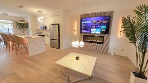 a living room with a large tv and a table at Nordic Three Brantford in Brantford +14 photos