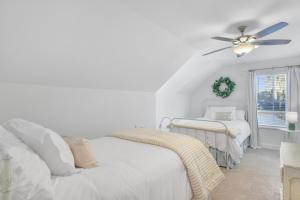 una camera da letto bianca con un letto e un ventilatore a soffitto di Marsh Views On Holly a Ebo Landing