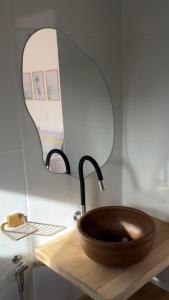 um banheiro com uma pia de madeira e um espelho em Vila Goa em Cruz