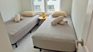 two beds in a room with a window at Nordic Three Brantford in Brantford