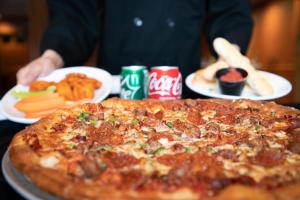 een pizza die bovenop een tafel staat met borden vol eten bij The Highlands at Harbor Springs in Harbor Springs