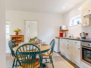 eine Küche mit einem Holztisch und Stühlen in der Unterkunft 2 Bed in West Knoyle 52105 in West Knoyle + 8 Fotos