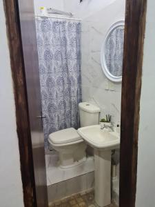 a bathroom with a toilet and a sink at Fashion Home in Guarambaré