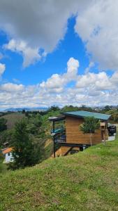 a house on a hill with a blue roof at Cabaña Martina con Jacuzzi in Marinilla +18 photos