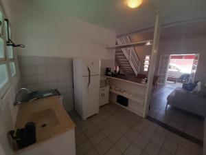 uma cozinha com um frigorífico e uma sala de estar em Pousada Pantai Maresias em Maresias