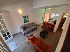 uma sala de estar com um sofá, cadeiras e uma mesa em Pousada Pantai Maresias em Maresias