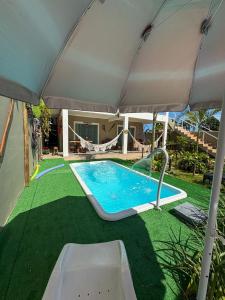 a swimming pool under an umbrella in a yard at Chalé do Gaúcho in Ubatuba +13 photos