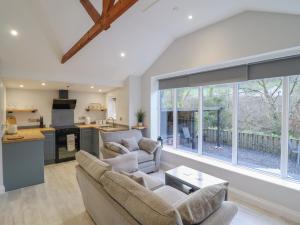 a living room with two couches and a kitchen at Lodge at Nadur in Machynlleth +17 photos