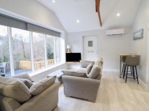 a living room with two couches and a large window at Lodge at Nadur in Machynlleth