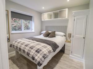 a bedroom with a bed and a window at Lodge at Nadur in Machynlleth