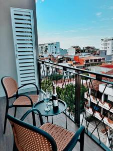 a balcony with two chairs and a table with a bottle of wine at OVATA 401- Zona Romántica in Puerto Vallarta