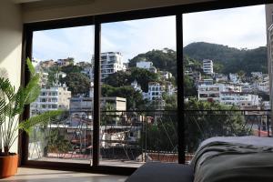 a bedroom with a view of a city at OVATA 401- Zona Romántica in Puerto Vallarta +1 photo