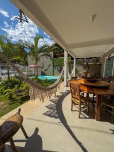 a patio with a hammock and a table and chairs at Chalé do Gaúcho in Ubatuba