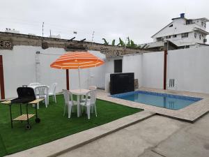 a patio with a table and chairs and an umbrella at Casa Familiar a 5 minutos de la playa in Salinas