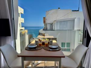 een tafel met drankjes op een balkon met uitzicht op de oceaan bij Melenara Beach in Melenara