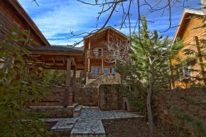 une maison en rondins avec un chemin de pierre devant dans l'établissement Ξενώνας Σαν Παραμύθι, à Sinoikía Mési Trikálon