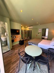 ein Zimmer mit zwei Betten, einem Tisch und Stühlen in der Unterkunft Hotel de Berne in Nizza