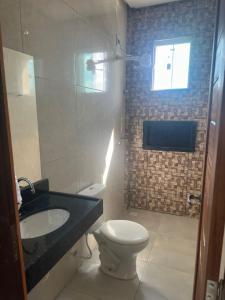 een badkamer met toilet, wastafel en raam bij Serra Village Hotel in Ubajara