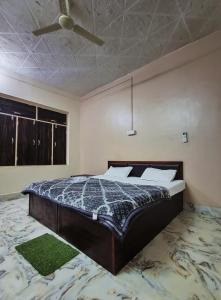 a bedroom with a bed and a ceiling fan at Brajrani Hotel in Datia