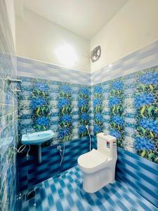 ein blau gefliestes Badezimmer mit Toilette und Waschbecken in der Unterkunft AK Residency Auroville in Kuilapayam + 13 Fotos