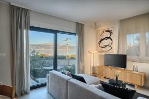 a living room with a couch and a large window at Tina's Tiny Beach House in Slatine