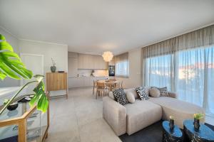 a living room with a couch and a kitchen at Tina's Tiny Beach House in Slatine