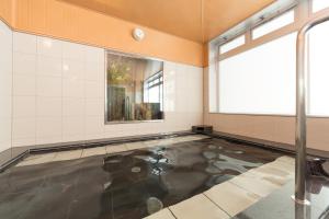 an empty swimming pool in a room with a window at Sanco Inn Tsu Ekimae in Tsu