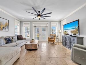 een woonkamer met een bank en een plafondventilator bij Blue Coconut in Destin