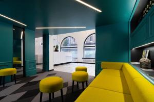 a room with a yellow couch and yellow chairs at Hôtel Diana Dauphine in Strasbourg