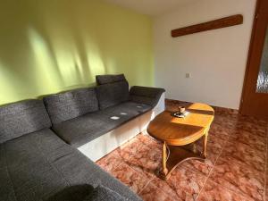 een woonkamer met een bank en een tafel bij Popasul din Valea Mare in Caransebeş