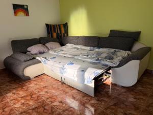 een bed in een kamer met een bank bij Popasul din Valea Mare in Caransebeş