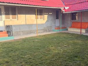 een huis met een rood dak en een groene tuin bij Popasul din Valea Mare in Caransebeş