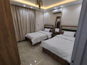 a hotel room with two beds and a window at مدينتي in Kafr Salīm