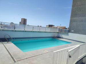 a swimming pool on the roof of a building at Departamento entero doble iquique in Iquique