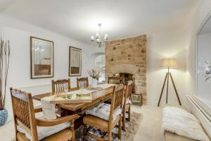 een eetkamer met een tafel en stoelen en een open haard bij 3 Bed in Mealsgate oc-e33626 in Mealsgate
