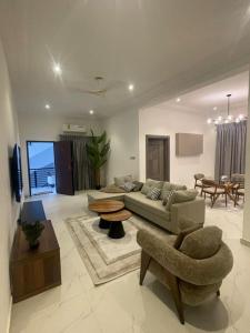 een woonkamer met een bank en een tafel bij Akyamaa's Place Apartments in Accra