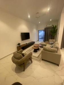 een woonkamer met twee banken en een flatscreen-tv bij Akyamaa's Place Apartments in Accra +4 foto's
