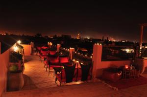 a row of chairs on a balcony at night at Riad Imilchil in Marrakesh
